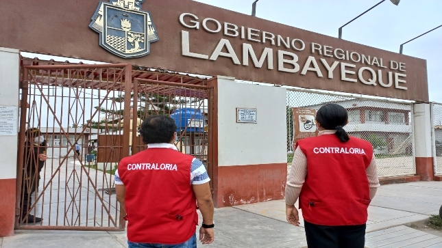 Imagen JPG de dos colaboradores de la Contraloría mirando la fachada de la puerta de ingreso del Gobierno Regional de Lambayeque.