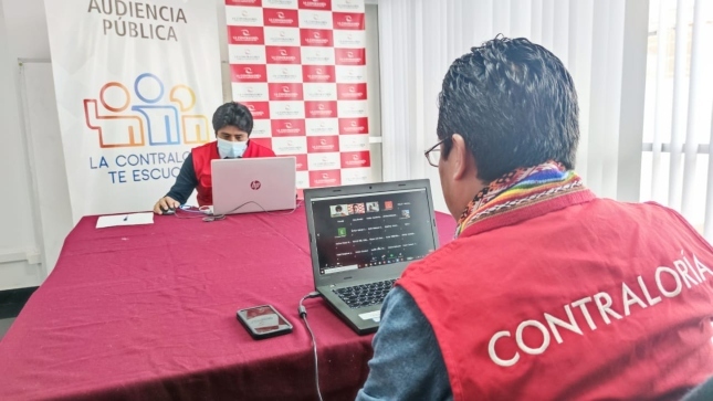 Imagen JPG de dos colaboradores de la Contraloría sentados en una mesa con sus laptops y participando de la Audiencia Pública virtual en Cusco.
