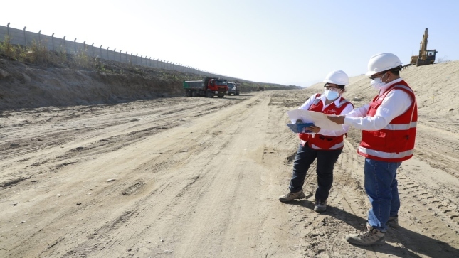 Imagen JPG de dos colaboradores de la Contraloría revisando un plano en las inmediaciones de la obra de control de inundaciones del río Ica.