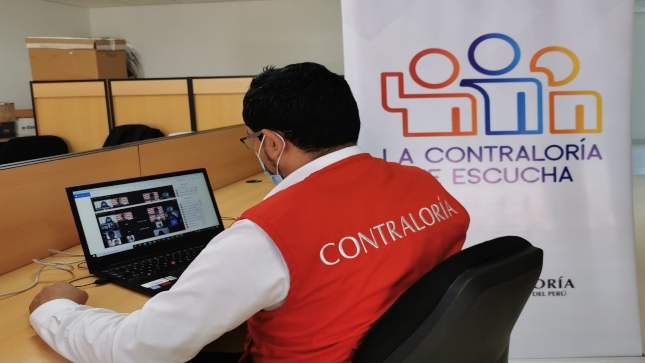 Imagen JPG de colaborador de la Contraloría sentado en su escritorio con su laptop participando de la Audiencia Pública virtual Ayacucho.