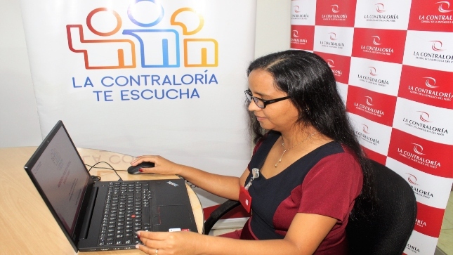 Imagen de colaboradora de la Contraloría sentada en su escritorio con su laptop participando de la Audiencia Pública Virtual “La Contraloría te escucha” en Tumbes.
