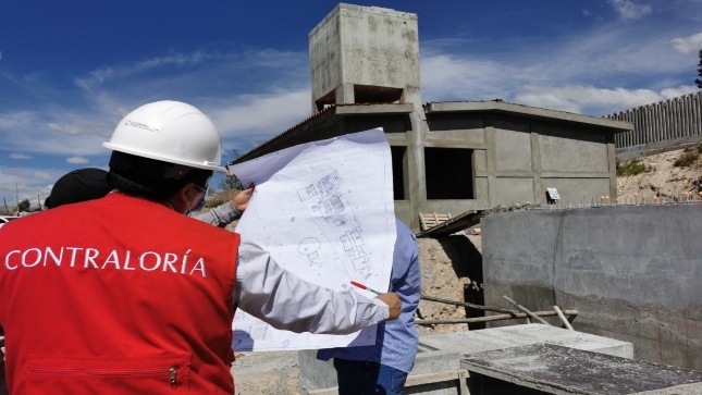 Archivo JPG de colaborador de la Contraloría revisando un plano de la obra de agua potable del sector Yanama en Ayacucho.