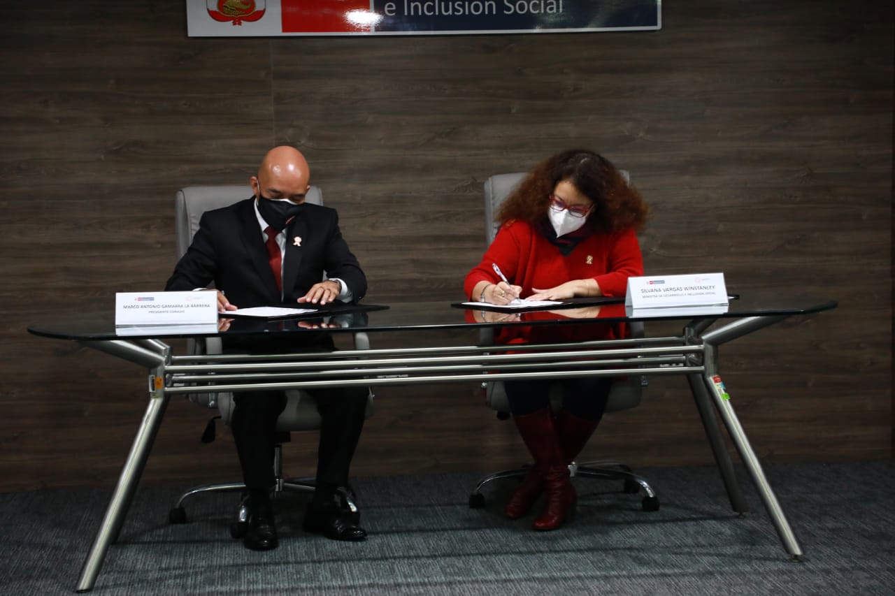 Presidente del Conadis, Marco Antonio Gamarra La Barrera junto a la Ministra de Desarrollo e Inclusión Social, Silvana Vargas Winstanley ambos están sentados y están firmando firmaron  el Convenio de Cooperación Interinstitucional 