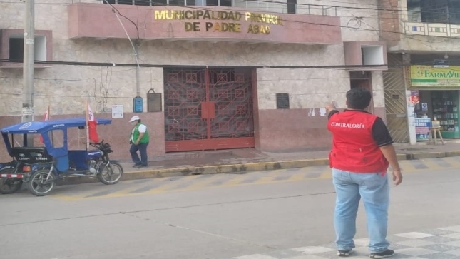 Imagen JPG de colaborador de la Contraloría señalando fachada de la Municipalidad Provincial de Padre Abad en Ucayali.