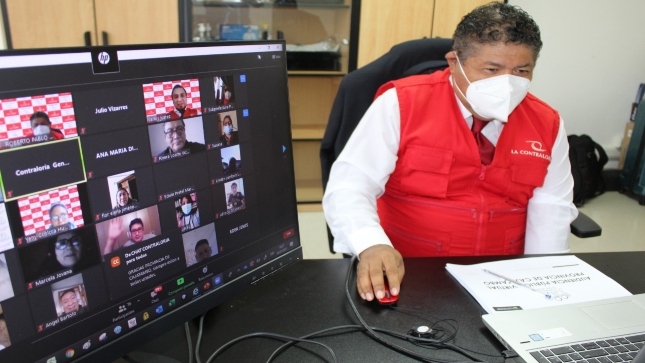 Imagen JPG de colaborador de la Contraloría y una pantalla de computadora con diferentes personas participando en una Audiencia Pública virtual en Lima Provincias.