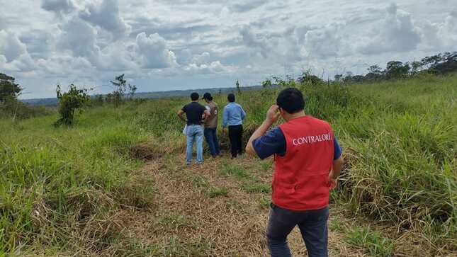 Imagen JPG de colaborador de la Contraloría y otras personas caminando por un terreno con áreas verdes en Madre de Dios.