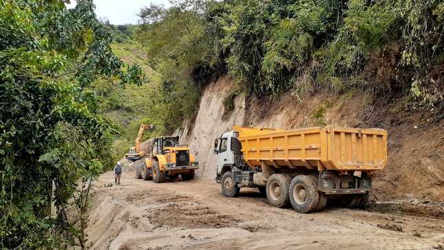 Imagen JPG de una carretera trocha con dos camiones en la ciudad de San Ignacio, Cajamarca.