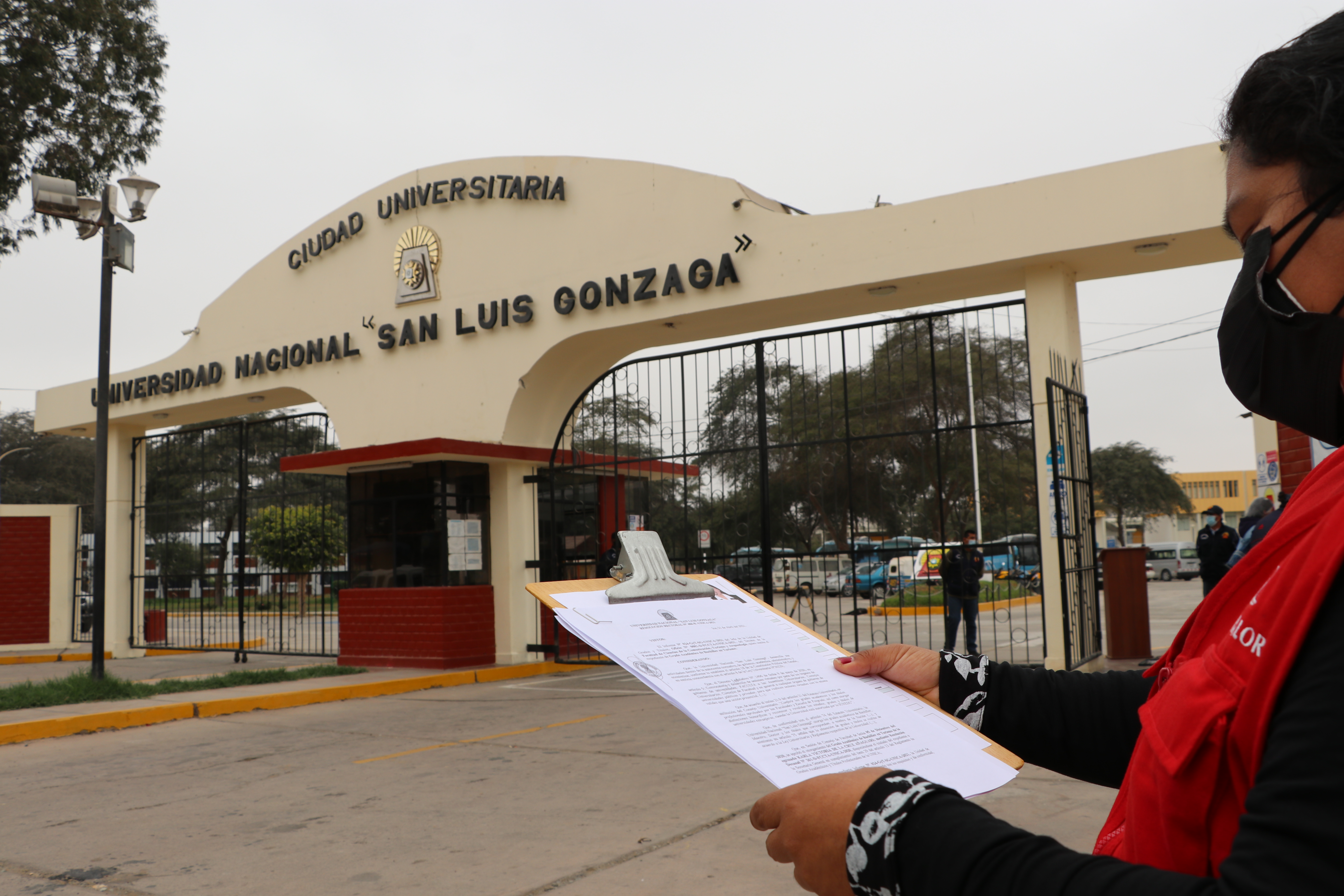 Imagen JPG de colaborador de la Contraloría en la puerta de ingreso de la Universidad San Luis Gonzaga de Ica.