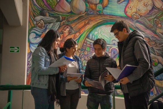 Estudiantes universitarios parados leyendo sus apuntes de sus cuadernos