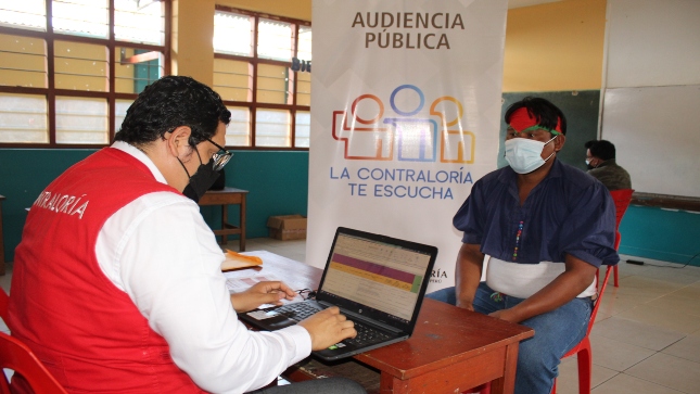 Auditor de Contraloría recibe las denuncias de un ciudadano que participa en una Audiencia Pública