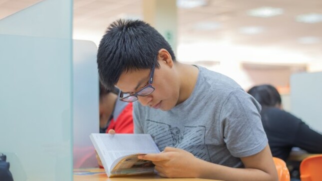 Estudiando leyendo un libro en una biblioteca