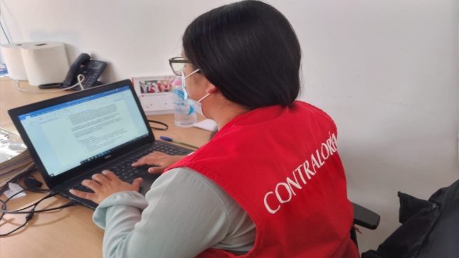 Auditora de Contraloría revisa documentación en su computadora