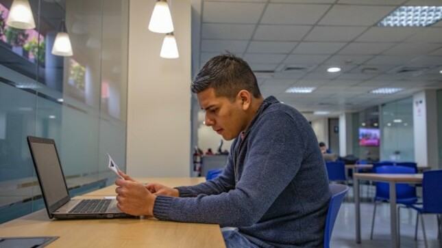 Estudiante leyendo un libro en una biblioteca