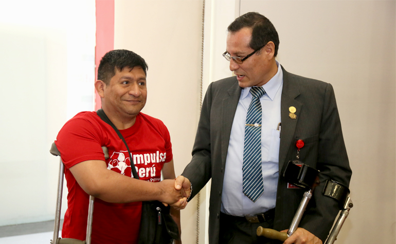 Presidente del Conadis estrechando la mano a asistente al taller.
