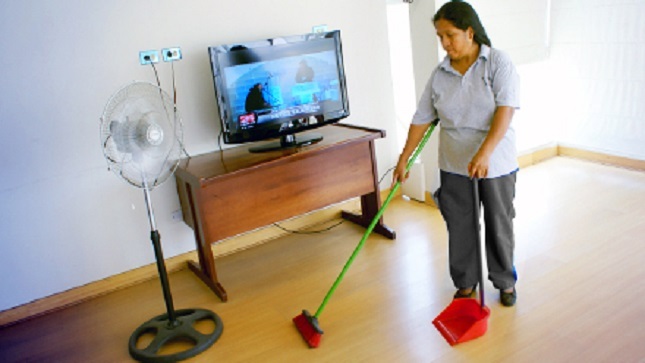 Una trabajadora del hogar realizando limpieza