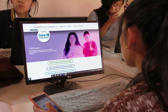Estudiante sentada frente a la computadora realizando su postulación virtual a Beca 18