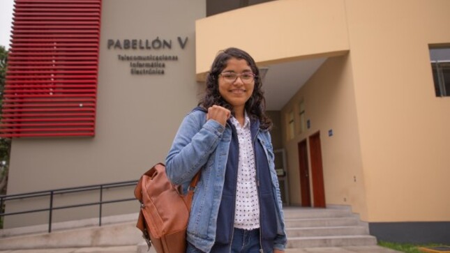 Estudiante parada en el frontis de su universidad