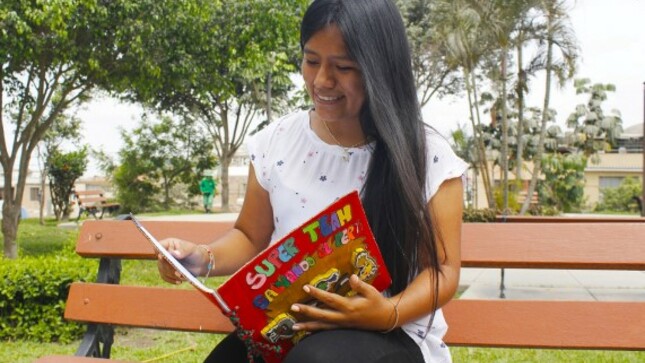 Joven docente revisando un libro 