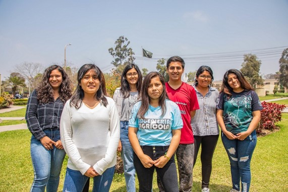 Jóvenes universitarios sonriendo y mirando a la cámara.