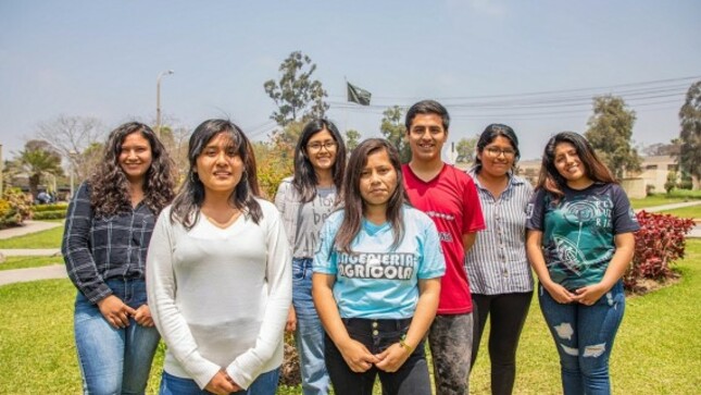 Jóvenes universitarios sonriendo y mirando a la cámara.