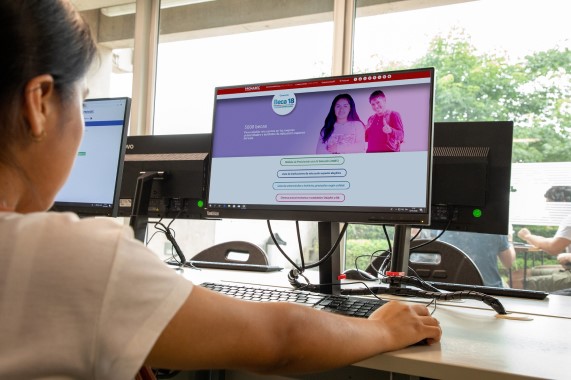 Estudiante frente a la computadora revisando la página web de Beca 18.