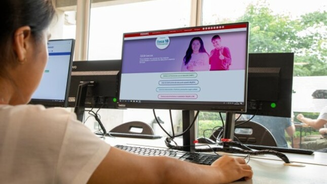 Estudiante frente a la computadora revisando la página web de Beca 18.