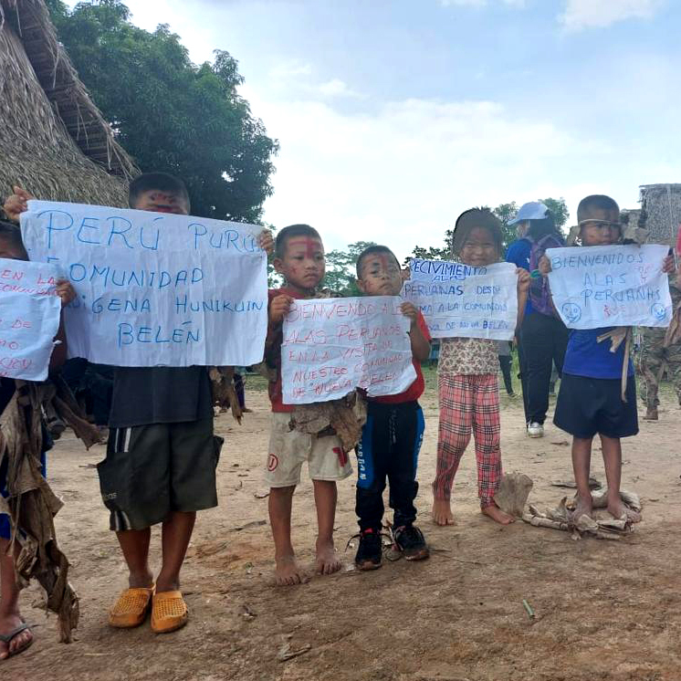 Fotografía de unos niños con sus pancartas de bienvenida a las autoridades que visitaban la comunidad de purus