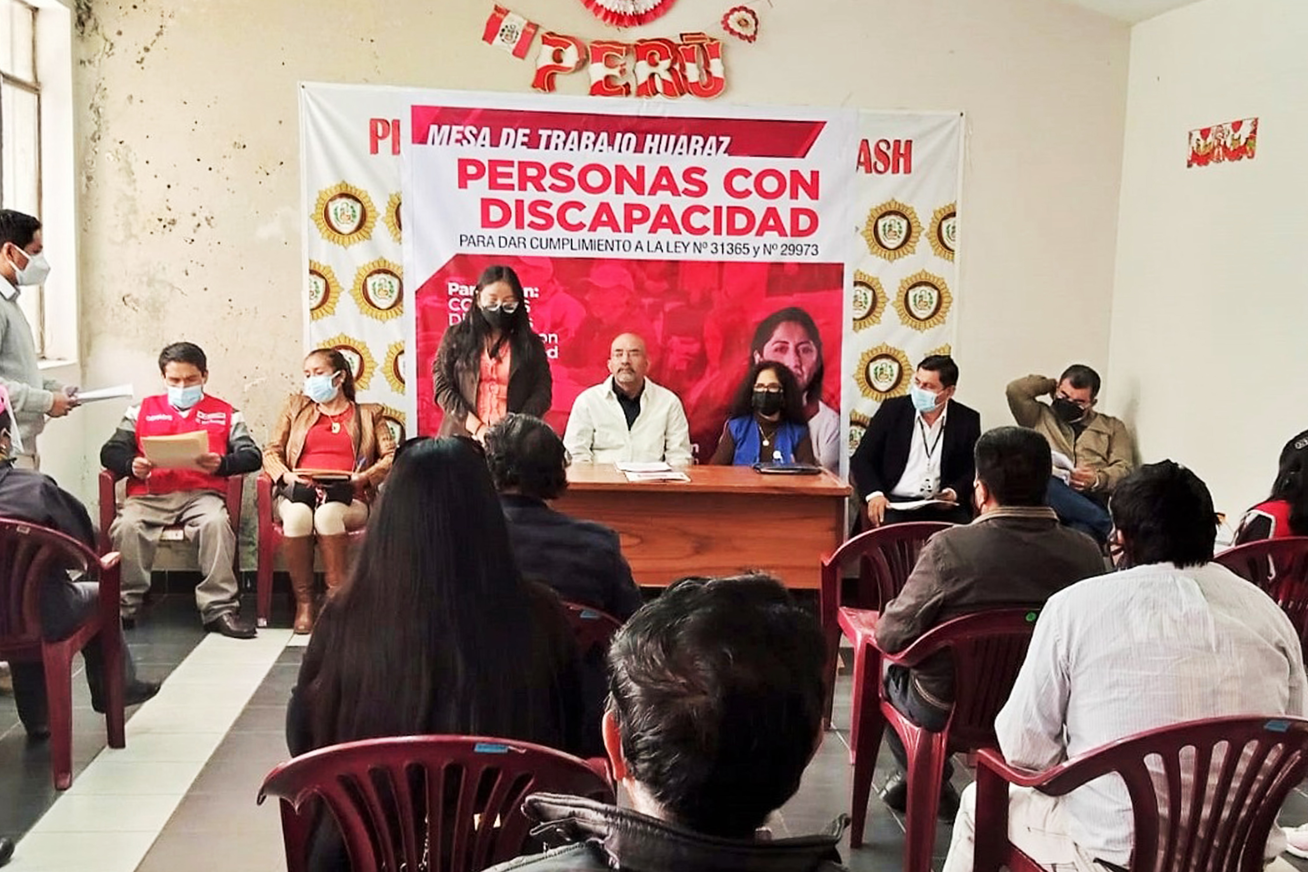 Fotografía del presidente del conadis en un aula y personas que han ido a escucharlo