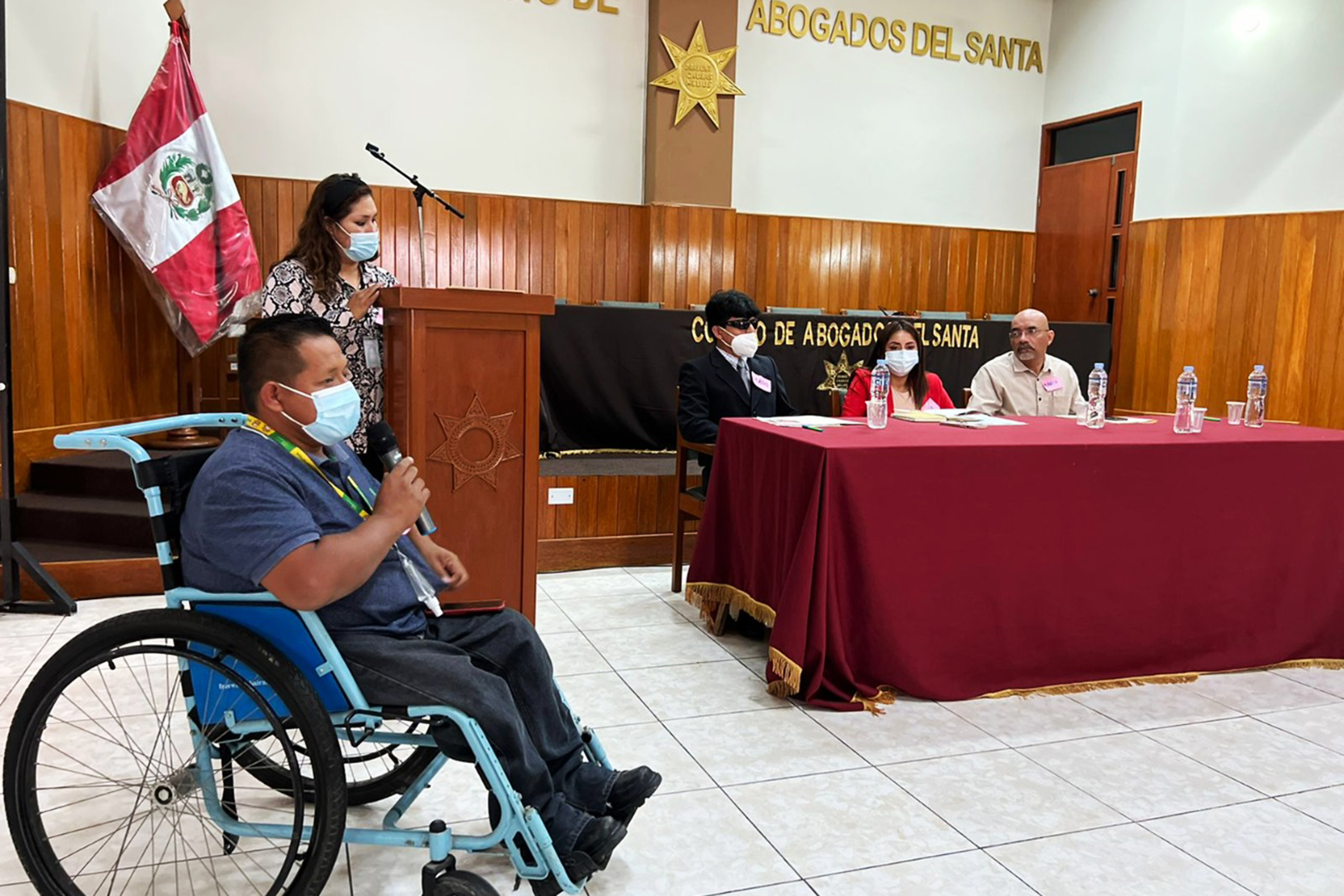 Fotografia del presidente del conadis escuchando a un hombre en silla de ruedas en el colegio de abogados