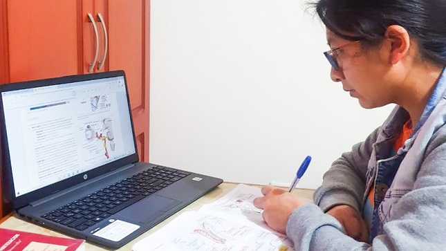 Joven estudiando frente a una computadora