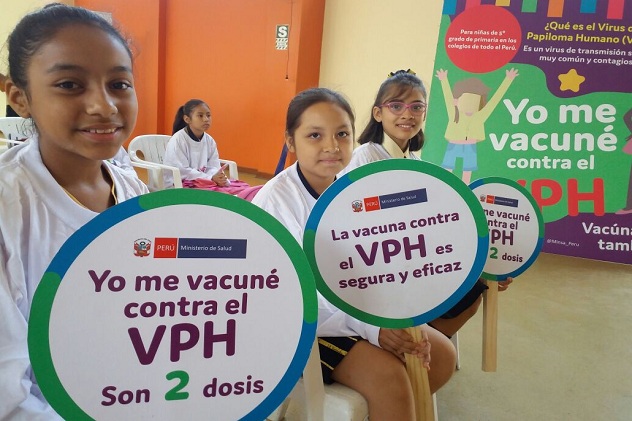 Chicas con carteles de la campaña contra el VPH. Los carteles dicen: Yo me vacuné contra el VPH. Son dos dosis.