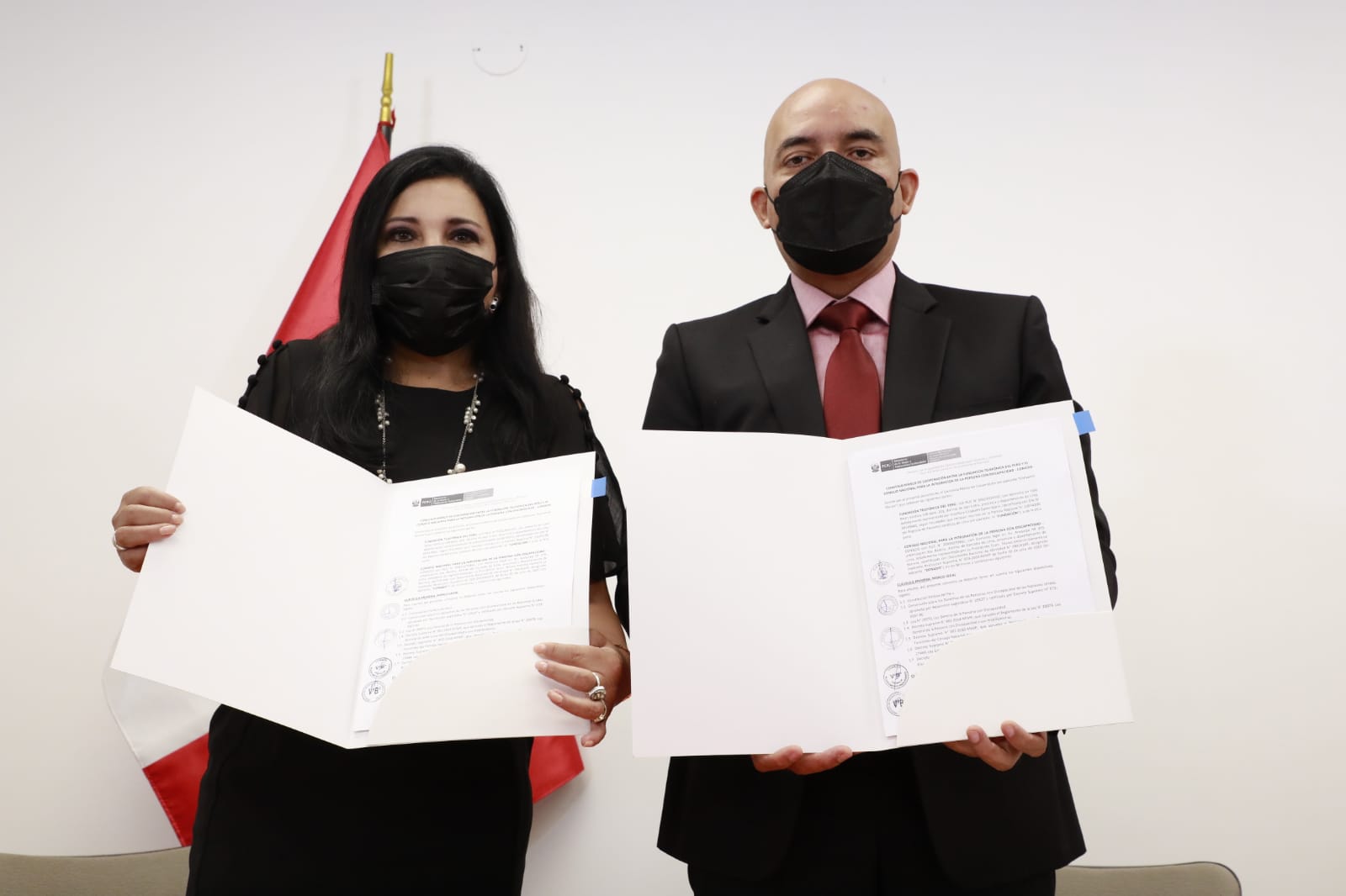 Fotografía del presidente del conadis junto a la representante Fundación Telefónica enseñando el convenio