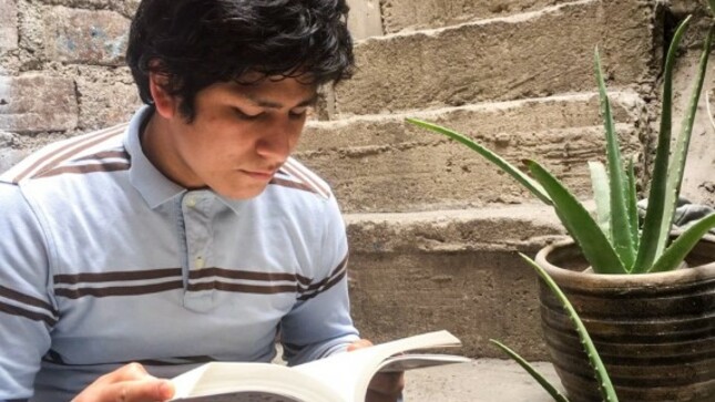 Joven leyendo un libro en una escalera