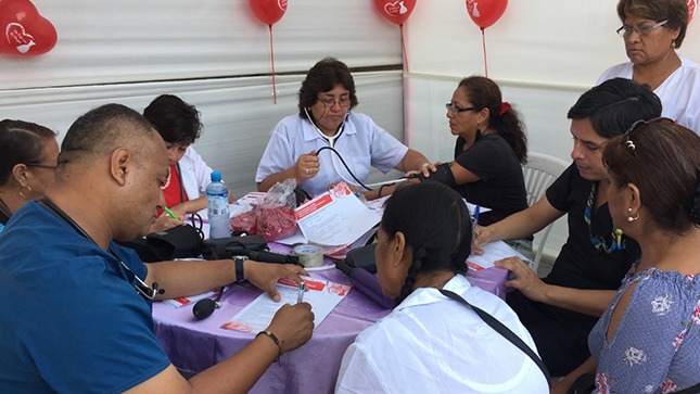 Profesionales de la salud miden la presión arterial a unas mujeres