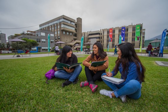 Estudiantes estudiantes sentadas en un parque dentro de su universidad.