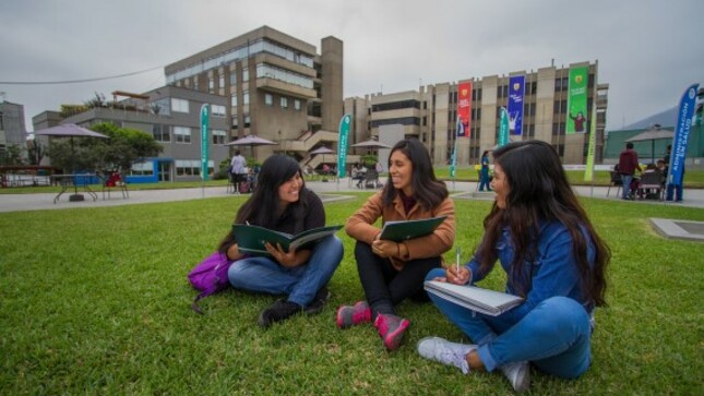 Estudiantes estudiantes sentadas en un parque dentro de su universidad.