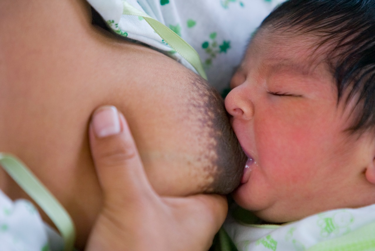 Una mamá da de lactar a su bebé.