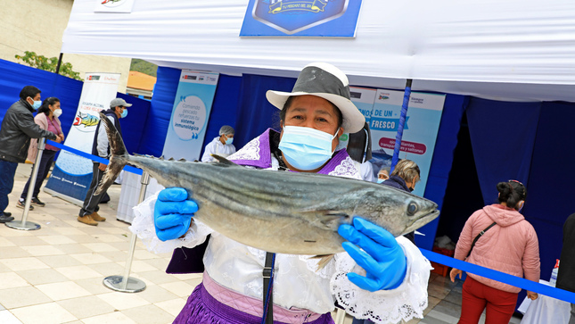 Imagen de señora sosteniendo un pescado fresco