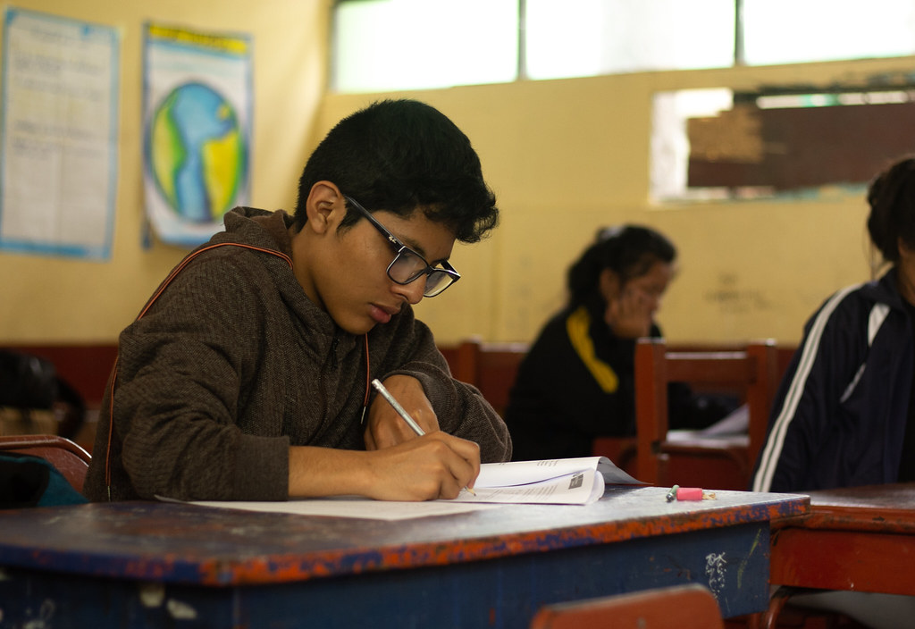 Un alumno estudia dentro de su aula.