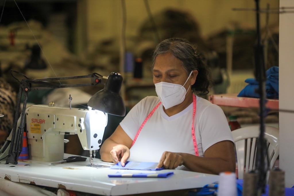 Imagen de mujer manejando una máquina textil