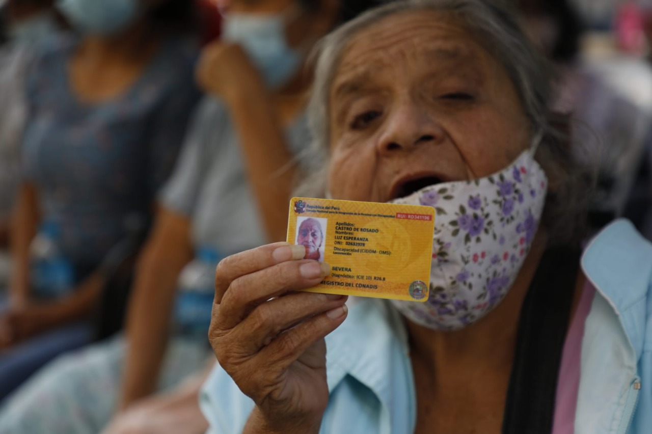 Persona con discapacidad adulta mayo mujer muestra su carnet del Conadis