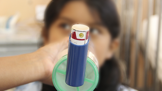 Se ve a una niña con un nebulizador por su crisis de asma. 