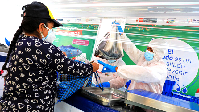 Imagen de mujer comprando pescado en feria "Mi Pescadería" del Programa Nacional "A Comer Pescado"