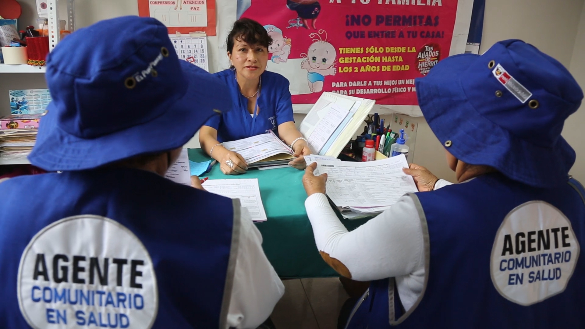 En la foto se ve a dos agentes comunitarios sentados.