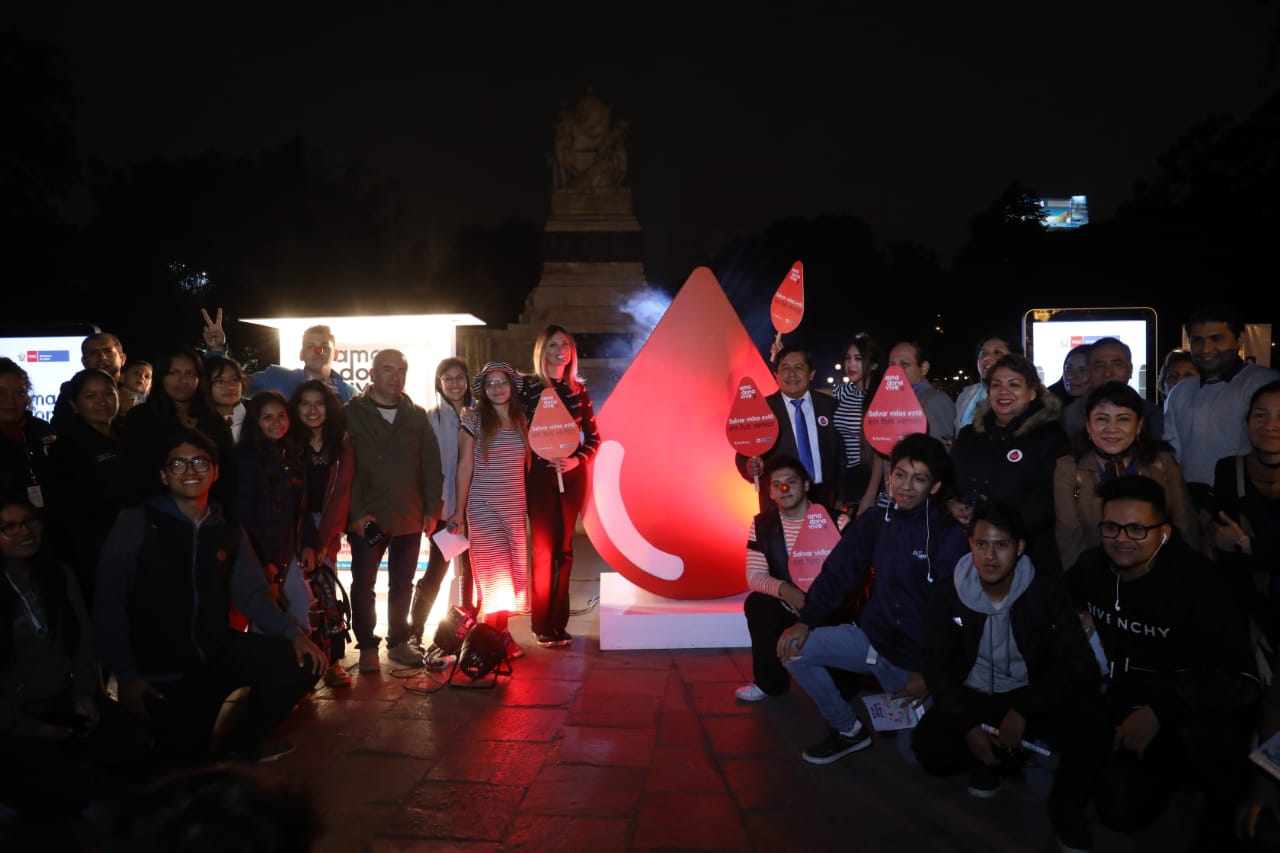 En la foto aparece un grupo de personas junto a la gota de sangre iluminada.