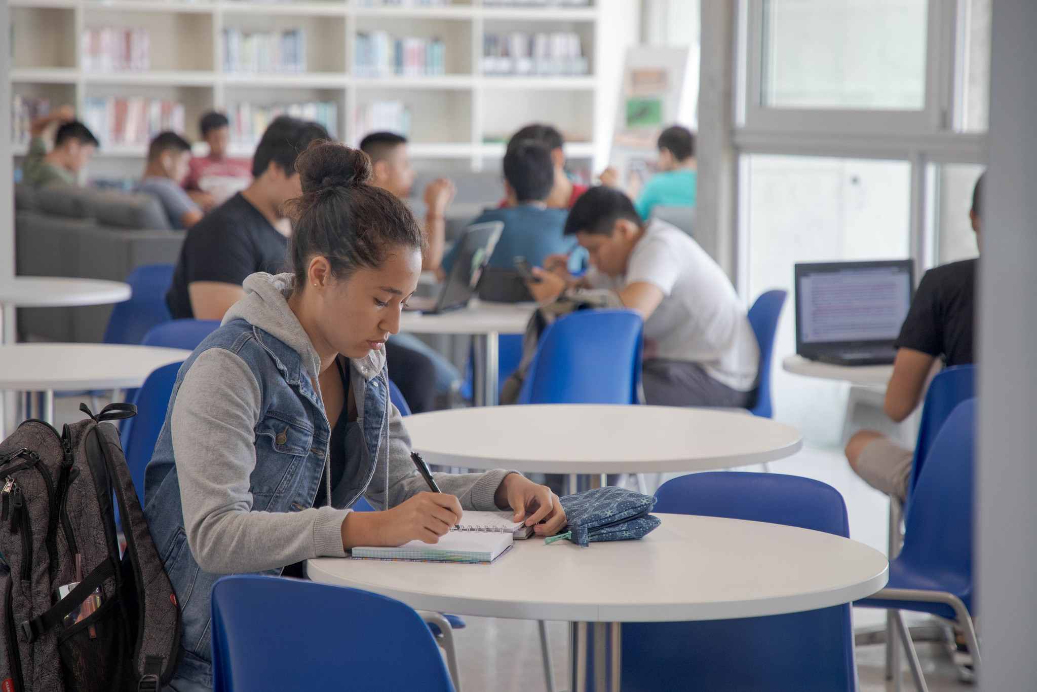 Joven estudiando en un salón de biblioteca