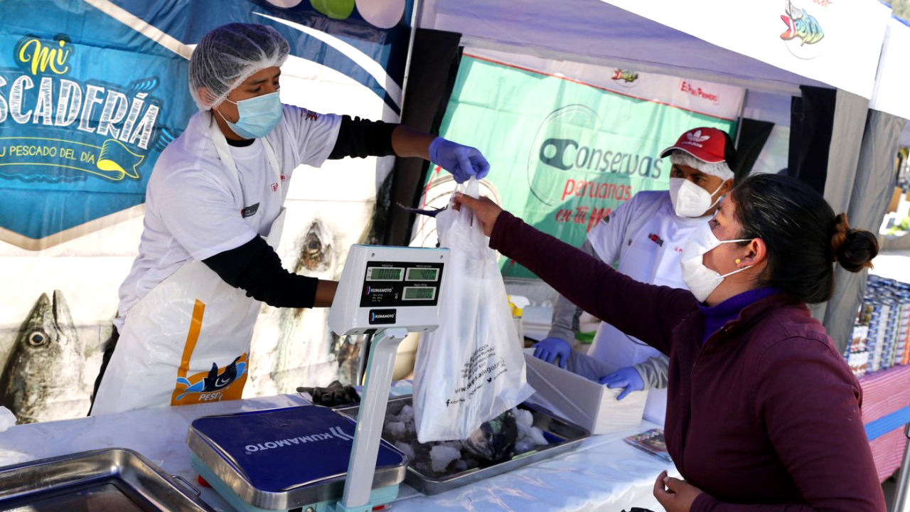 Imagen de mujer comprando pescado en feria "Mi Pescadería"