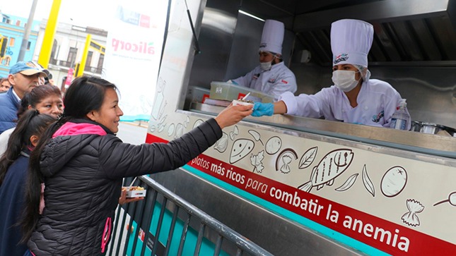 En la foto aparece personas recibiendo del Food Truck comida rica en hierro.