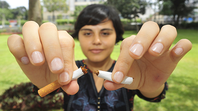 Una mujer tiene un cigarrillo en su mano