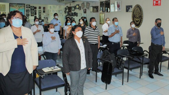 Autoridades y docentes cantando el Himno Nacional